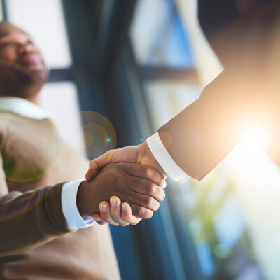 Closeup shot of two businessmen shaking hands in an office